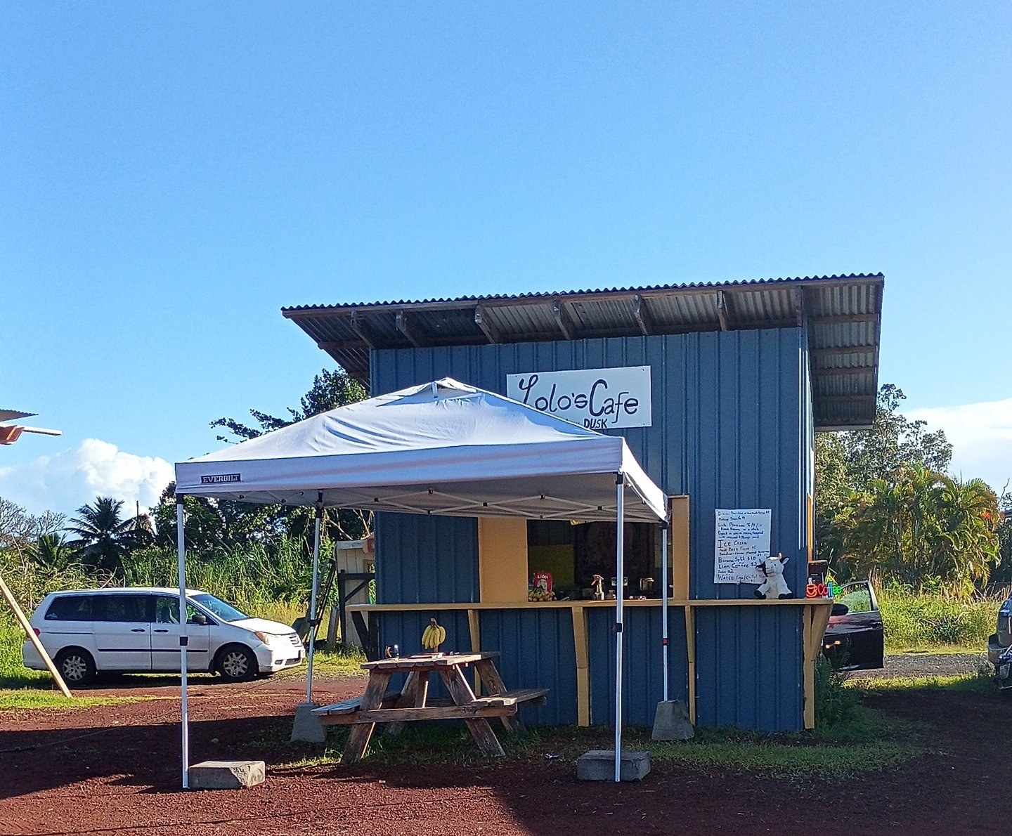 Lolo’s Cafe booth on Hwy 130. Blue stand, white tent, picnic table.